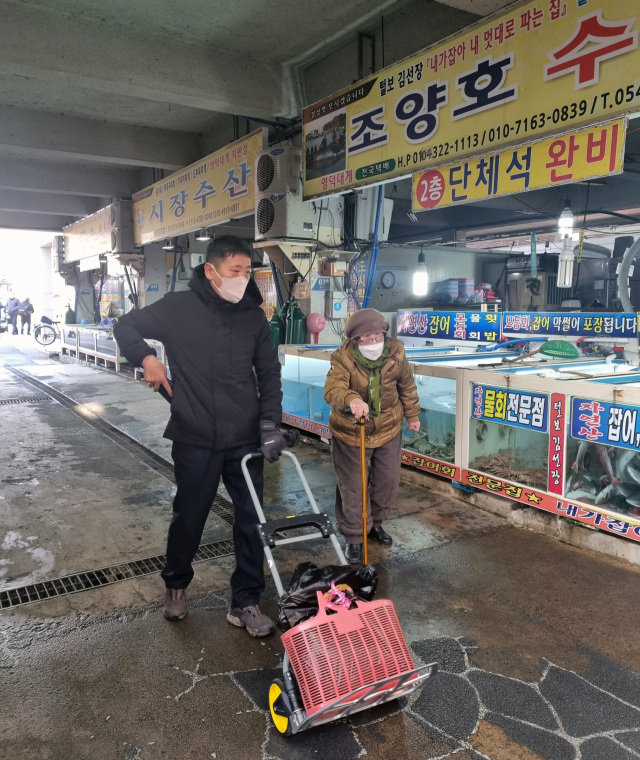 영덕군에서는 설명절을 맞아 대대적인 전통시장 장보기 행사가 이어지고 있다. 영덕군청 직원이 강구시장에서 어르신 장바구니 들어주기 봉사를 하고 있다.영덕군 제공