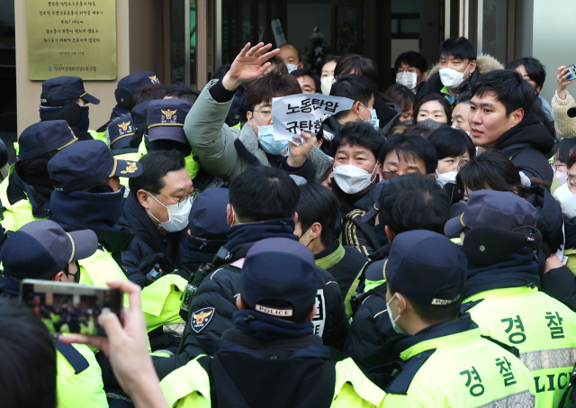 18일 오후 국정원이 압수수색 중인 서울 영등포구 민주노총 전국보건의료산업노동조합 사무실 입구에서 경찰이 압수수색 종료 때 손팻말 시위를 하려는 노조원들을 막아서고 있다. 연합뉴스