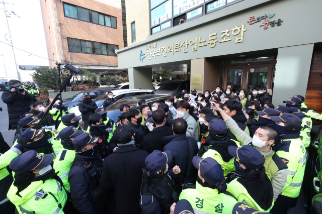 18일 오후 국정원이 압수수색 중인 서울 영등포구 민주노총 전국보건의료산업노동조합 사무실 입구에서 경찰이 압수수색 종료 때 손팻말 시위를 하려는 노조원들을 막아서고 있다. 연합뉴스