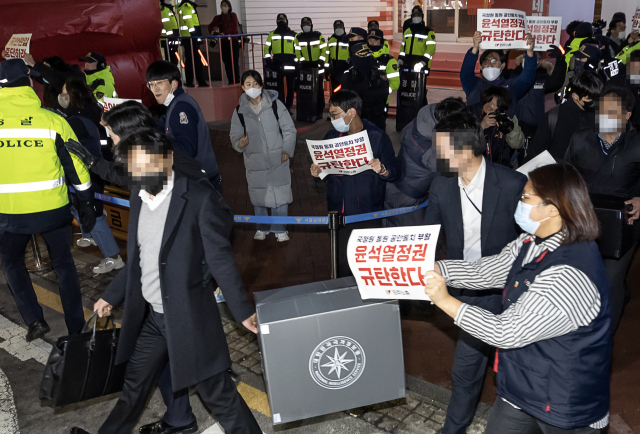 국가정보원이 지난 1월 18일 오후 서울 중구 전국민주노동조합총연맹(민주노총) 서울 사무실 압수수색을 마친 후 압수물이 든 상자를 들고 나가고 있다. 연합뉴스