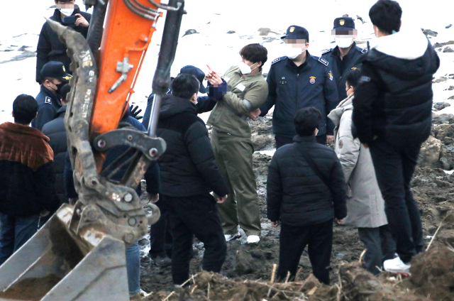 택시 기사와 동거녀를 살해한 혐의로 구속된 이기영이 6일 오후 경기도 파주 공릉천변에서 검찰 관계자들에게 시신을 매장했다고 진술한 부근을 손으로 가리키고 있다. 연합뉴스