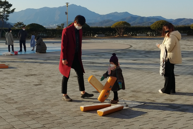 칠곡호국평화기념관 야외 호국광장에서 가족이 윷놀이를 즐기고 있다. 칠곡호국평화기념관 제공