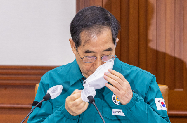한덕수 국무총리가 20일 오전 서울 종로구 정부서울청사에서 열린 코로나19 중앙대책본부 회의에 참석해 발언하기 위해 마스크를 벗고 있다. 이날 중대본 회의를 거쳐 정부는 오는 30일부터 실내마스크 의무를 권고로 변경할 계획이다. 실내마스크 권고에는 의료기관과 대중교통은 제외된다. 연합뉴스