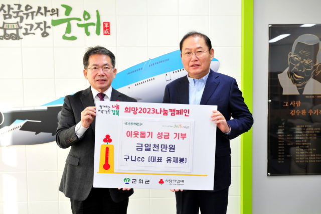 유재봉(오른쪽) 구니CC 대표가 김진열 군위군수에게 이웃돕기 성금을 기탁하고, 기념 사진을 촬영하고 있다. 군위군 제공