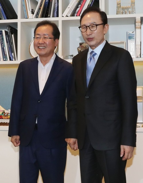 지난 2017년 7월 25일 오후 서울 강남구 대치동 이명박 전 대통령 사무실에서 만나 손을 꼭 잡은 홍준표 대구시장(당시 자유한국당 대표)과 이명박 전 대통령. 연합뉴스