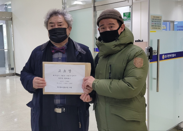 이채원(왼쪽) 이인성기념사업회 회장과 이상옥 관리이사가 대구중부경찰서에서 대구 중구의원 2명을 상대로 한 고소장을 들어보이고 있다. 이채원 회장 제공