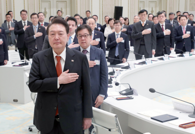 윤석열 대통령이 30일 오후 청와대 영빈관에서 열린 금융위원회 업무보고에서 국기에 경례하고 있다. 연합뉴스