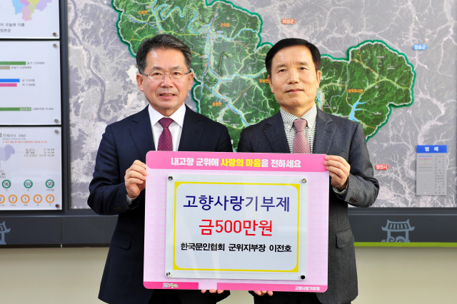 이전호(오른쪽) 한국문인협회 군위지부장이 군위군에 고향사랑기부금 500만원을 기탁하고, 김진열 군수와 기념 사진을 촬영하고 있다. 군위군 제공