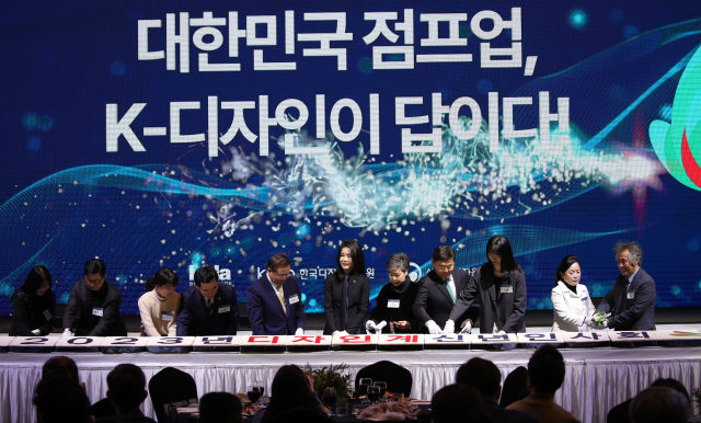김건희 여사가 31일 오후 경기 성남 분당구 코리아디자인센터에서 열린 디자인계 신년 인사회에서 참석자들과 떡 케이크를 자르고 있다. 연합뉴스