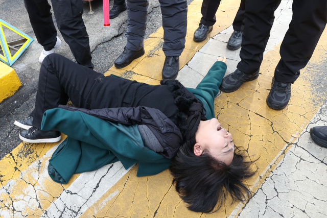 이태원 참사 희생자 이지한 씨 어머니인 조미은 씨가 31일 서울 용산구 대통령실 앞에서 윤석열 대통령과의 면담을 요구하며 출입문에 접근하던 중 경찰에게 저지당하고 있다. 연합뉴스