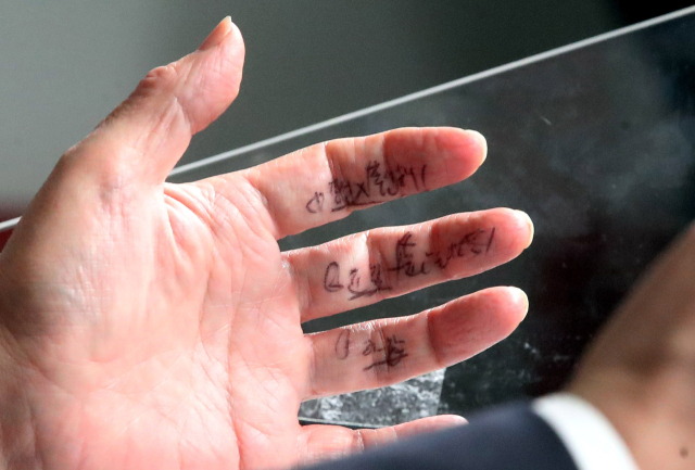 국민의힘 당권주자인 안철수 의원이 2일 오전 서울 여의도 중앙당사에서 당 대표 후보 등록을 마친 뒤 손가락에 적힌 메모를 보며 기자들에게 입장을 밝히고 있다. 연합뉴스
