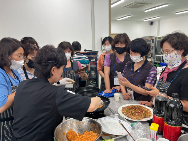 경북 청송군 우리음식연구회 회원들이 요리 전문가의 시연을 휴대전화로 촬영하는 모습. 청송군 제공