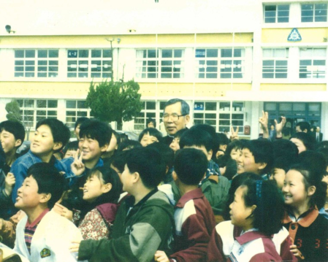 김수환 추기경이 1993년 5월 졸업 후 처음으로 모교를 방문해 후배 어린이들에게 둘러쌓여 기념 사진을 촬영하고 있다. 군위초교 제공