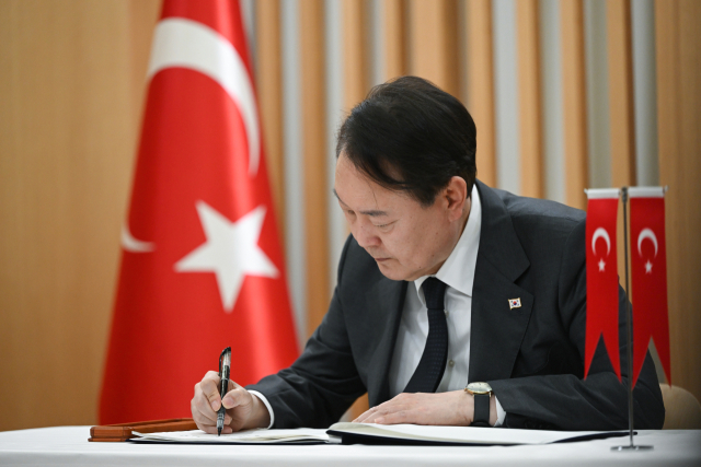 윤석열 대통령이 9일 서울 중구 주한 튀르키예 대사관을 방문, 희생자들을 애도한 뒤 조문록을 작성하고 있다. 연합뉴스