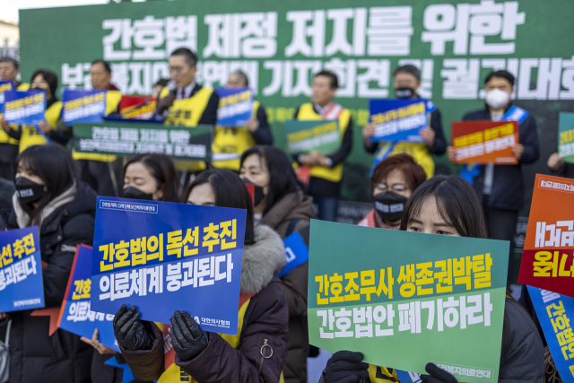 9일 오전 국회 앞에서 열린 간호법안 제정 저지를 위한 기자회견에서 보건복지의료연대회원들이 관련 내용이 적힌 피켓을 들고 있다. 연합뉴스