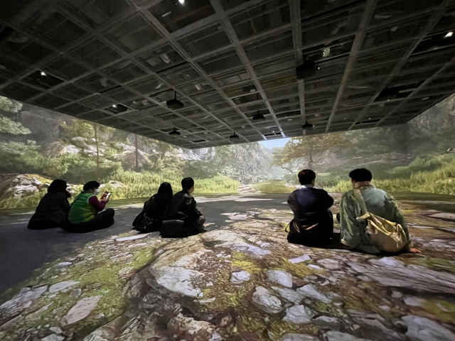 울산시립미술관 XR랩을 찾은 방문객들이 작품을 관람하고 있다. 신윤복의 단오풍정을 재해석한 작품이 3개 면과 바닥에 영상으로 펼쳐진다. 이연정 기자