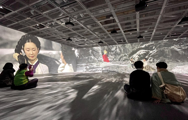 울산시립미술관 XR랩을 찾은 방문객들이 작품을 관람하고 있다. 신윤복의 단오풍정을 재해석한 작품이 3개 면과 바닥에 영상으로 펼쳐진다. 이연정 기자