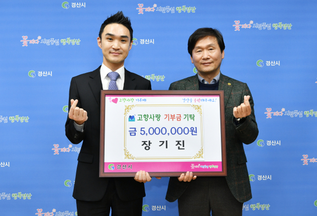 장기진(왼쪽) ㈜애플애드벤처 대표가 15일 경산시청을 방문해 조현일 시장에게 고향사랑기부금 500만원을 전달했다.