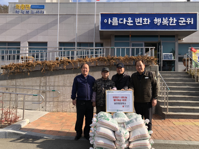 경북 군위군 의흥면의 장노출 남천방정미소 대표가 의흥면에 쌀을 기탁하고, 기념 사진을 촬영하고 있다. 군위군 제공