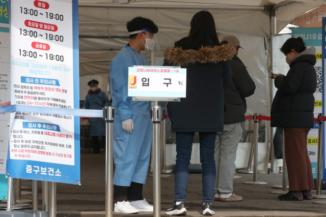 국내 코로나19 누적 확진자가 3천만 명을 넘어선 23일 오후 서울역광장에 마련된 임시선별검사소를 찾은 시민들이 의료진 안내를 받고 있다. 연합뉴스