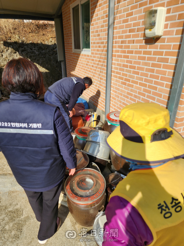 물이 새고 있는 수도꼭지를 들여다보고 있는 청송군 8282민원처리팀. 전종훈 기자