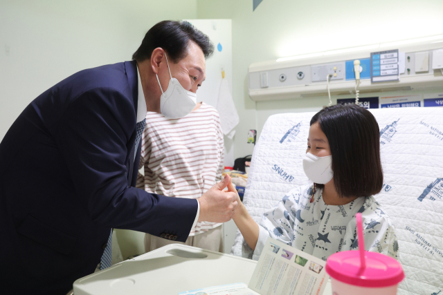 윤석열 대통령이 22일 서울 종로구 서울대학교어린이병원 소아외과 병동을 방문, 입원 중인 어린이와 보호자를 격려하고 있다. 연합뉴스