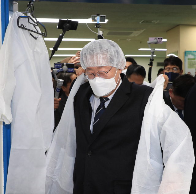 더불어민주당 이재명 대표가 28일 학교 급식실 노동자 폐암 진단과 관련해 서울 은평구 수색초등학교를 방문, 조리실을 둘러보기 전 위생복을 착용하고 있다. 연합뉴스