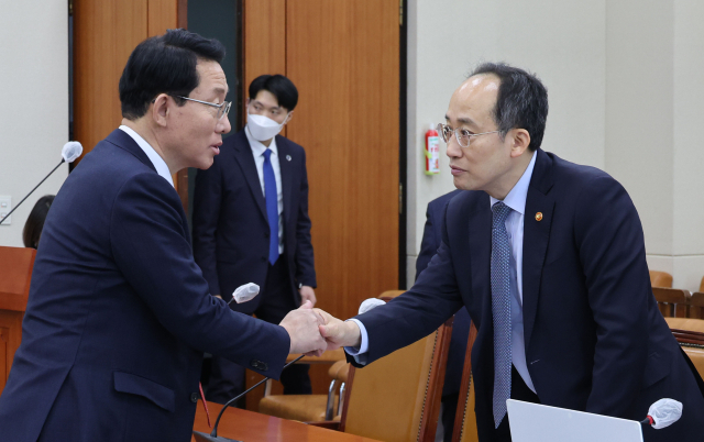 추경호 부총리 겸 기획재정부 장관이 14일 오전 서울 여의도 국회에서 열린 기획재정위원회 전체회의에서 국민의힘 김상훈 의원과 악수하고 있다. 연합뉴스
