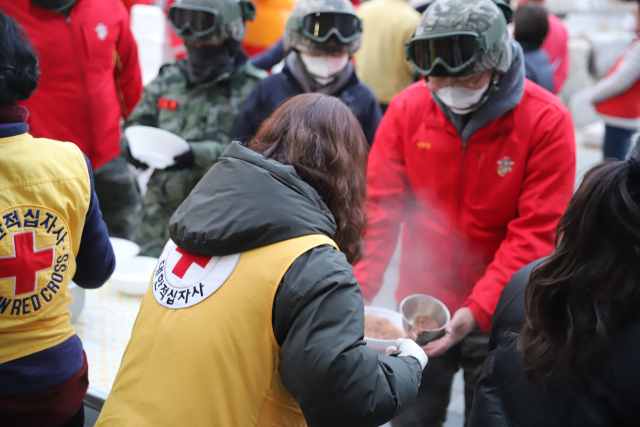 경북적십자 봉사자가 울진 산불 복구에 나선 해병대원에게 급식을 나눠주고 있다. 경북적십자 제공