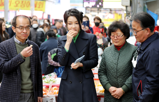 김건희 여사가 3일 경북 포항 죽도시장을 방문해 상인과 대화를 나누며 사과를 맛보고 있다. 김영진 기자 kyjmaeil@imaeil.com