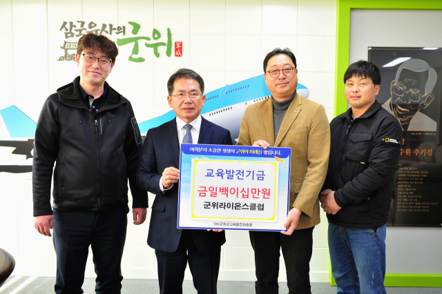 박용민 군위라이온스클럽 회장이 군위군에 교육발전기금을 기탁하고, 김진열 군수와 기념 사진을 촬영하고 있다. 군위군 제공