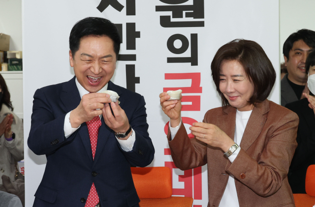 국민의힘 김기현 당 대표 후보가 6일 오전 서울 동작구에서 열린 동작을 당협 당원간담회에 참석해 당협위원장인 나경원 전 의원과 함께 찹쌀떡을 먹고 있다. 연합뉴스