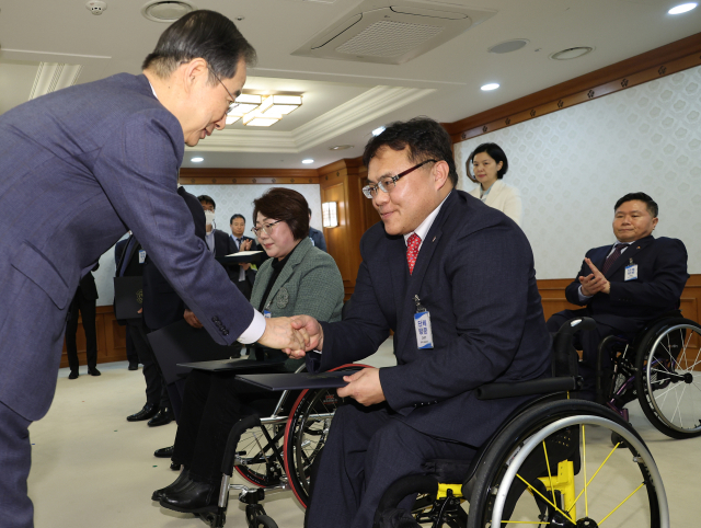 한덕수 국무총리가 9일 정부서울청사에서 열린 장애인정책조정위원회에 앞서 민간위원을 위촉하고 있다. 연합뉴스