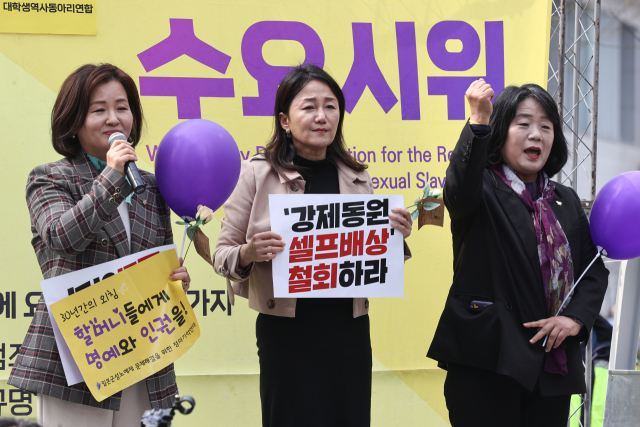 무소속 윤미향 의원(오른쪽)이 8일 오후 서울 종로구 옛 일본대사관 인근에서 열린 일본군 성노예제 해결을 위한 제1586차 수요시위에서 더불어민주당 이수진 의원(왼쪽), 이재정 의원과 함께구호를 외치고 있다. 연합뉴스