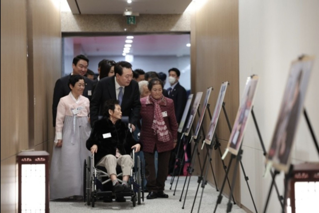 윤석열 대통령이 칠곡할매글꼴 이종희 할머니의 휠체어를 직접 밀며 대통령실 복도에 전시된 할머니들의 작품을 살펴보고 있다. 대통령실 제공