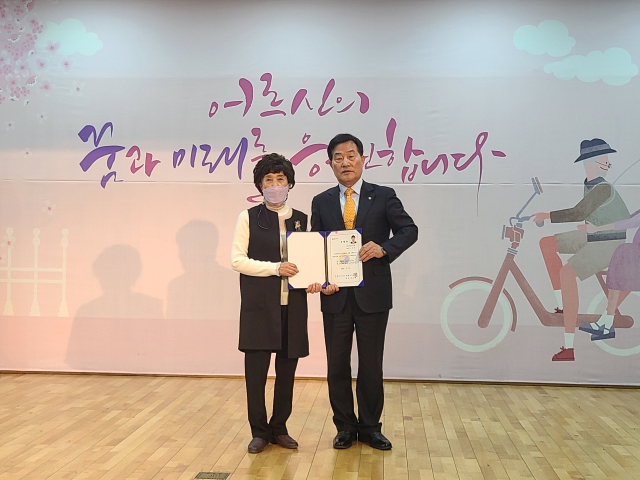 고정환 문경시노인회장이 문경수지침봉사회장으로 활동하고 있는 박해숙 씨에게 문경노인대학장 위촉장을 전달하고 있다. 대한노인회 문경시지회 제공