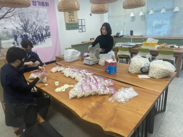 대구농업마이스터고의 담쿱사회적협동조합이 고산3동 행정복지센터에 기부할 떡국떡에 스티커를 붙이고 있다. 대구시교육청 제공