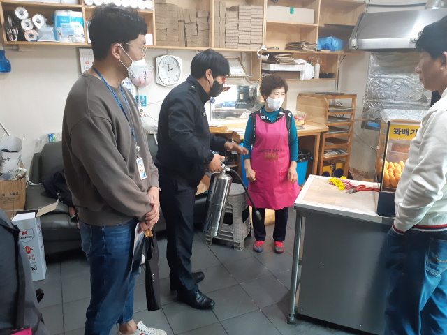 22일 대구 서부소방서 직원들이 음식점주에게 K급 소화기 사용법을 설명하고 있다. 서부소방서 제공.