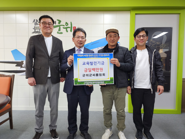 경북 군위군 씨름협회 임원들이 군위군에 교육발전기금을 기탁하고, 김진열 군수와 기념 사진을 촬영하고 있다. 군위군 제공