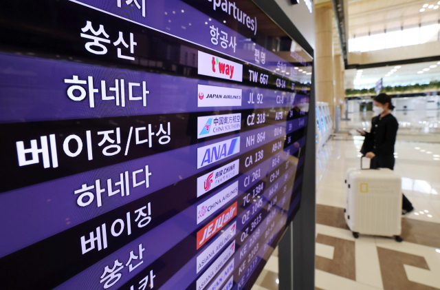 코로나19 사태로 중단된 김포-중국 노선 운항이 재개된 가운데 27일 김포국제공항 국제선 출국장에 설치된 전광판에 비행 일정이 표시돼 있다. 연합뉴스