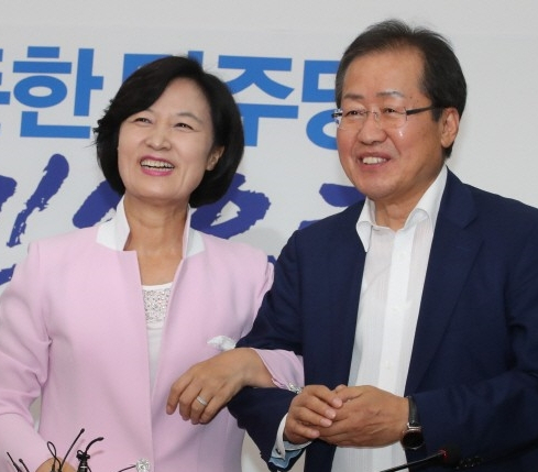 2017년 7월 4일 자유한국당 새 대표로 선출된 홍준표 시장이 당시 추미애 더불어민주당 대표와 만나 팔짱을 한 모습. 당시는 문재인 전 대통령 임기 초기로, 더불어민주당이 여당, 자유한국당은 제1야당이었다. 연합뉴스