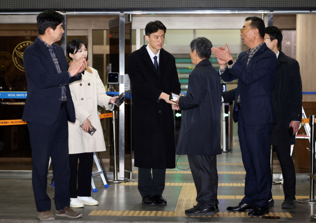 마약 투약 혐의 관련 조사를 마치고 석방된 전두환 전 대통령의 손자 전우원 씨가 29일 오후 서울 마포경찰서에서 전태일 열사의 동생 전태삼 씨와 인사하고 있다. 양옆에서 5·18 관련 단체(부상자회·공로자회) 회원들이 전씨에게 박수를 보내고 있다. 연합뉴스