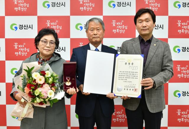 6·25전쟁에 참전해 공을 세운 고(故) 정성남 상병의 자녀 정대영(가운데) 씨가 조현일 경산시장으로부터 화랑무공훈장과 기념패를 전수받았다. 경산시 제공