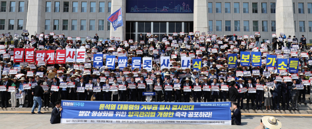 3일 국회 본청 계단 앞에서 열린 쌀값 정상화법 공포 촉구 결의대회에서 더불어민주당 의원들과 농민단체 회원들이 구호를 외치고 있다. 연합뉴스