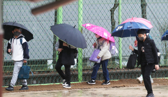 5일 오전 전북 전주시 문학초등학교 학생들이 우산을 쓰고 등교하고 있다. 연합뉴스