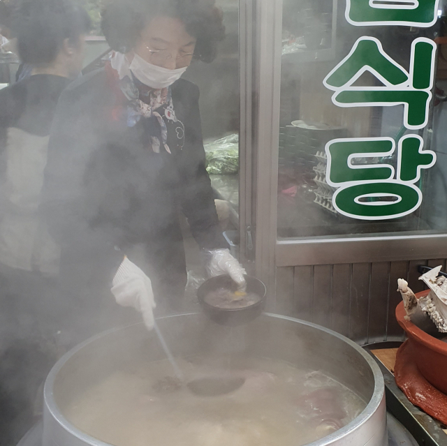 윤향란 평남식당 사장이 미리 잘라놓은 소머리 고기에 뜨거운 국물을 부었다 따라내면서 토렴 작업을 하고 있다. 신동우기자