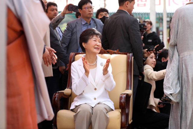 박근혜 전 대통령이 11일 오전 대구 팔공산 동화사를 찾아 통일대불 앞에서 큰스님의 덕담을 들으며 박수치고 있다. 연합뉴스