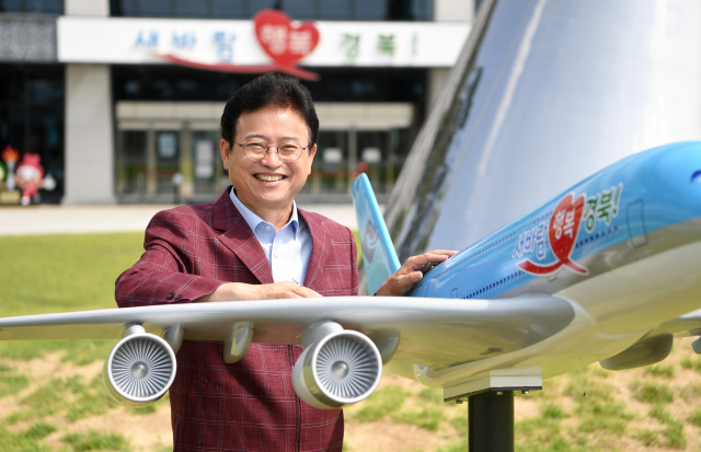 이철우 경북도지사가 경북도청 앞에서 항공기 모형과 함께 대구경북신공항을 통해