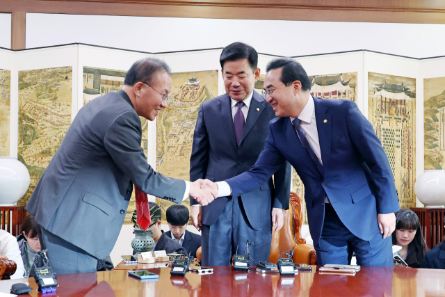 국민의힘 윤재옥 원내대표(왼쪽)와 더불어민주당 박홍근 원내대표가 12일 오전 국회에서 열린 김진표 국회의장 주재 교섭단체 원내대표 회동에서 악수하고 있다. 연합뉴스