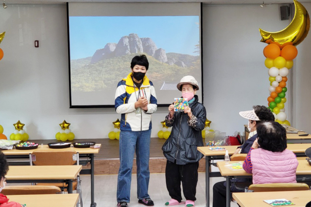 청송 유네스코 세계지질공원 프로그램에 참여한 한 어르신이 자신이 만든 작품을 설명하고 있는 모습. 청송군 제공